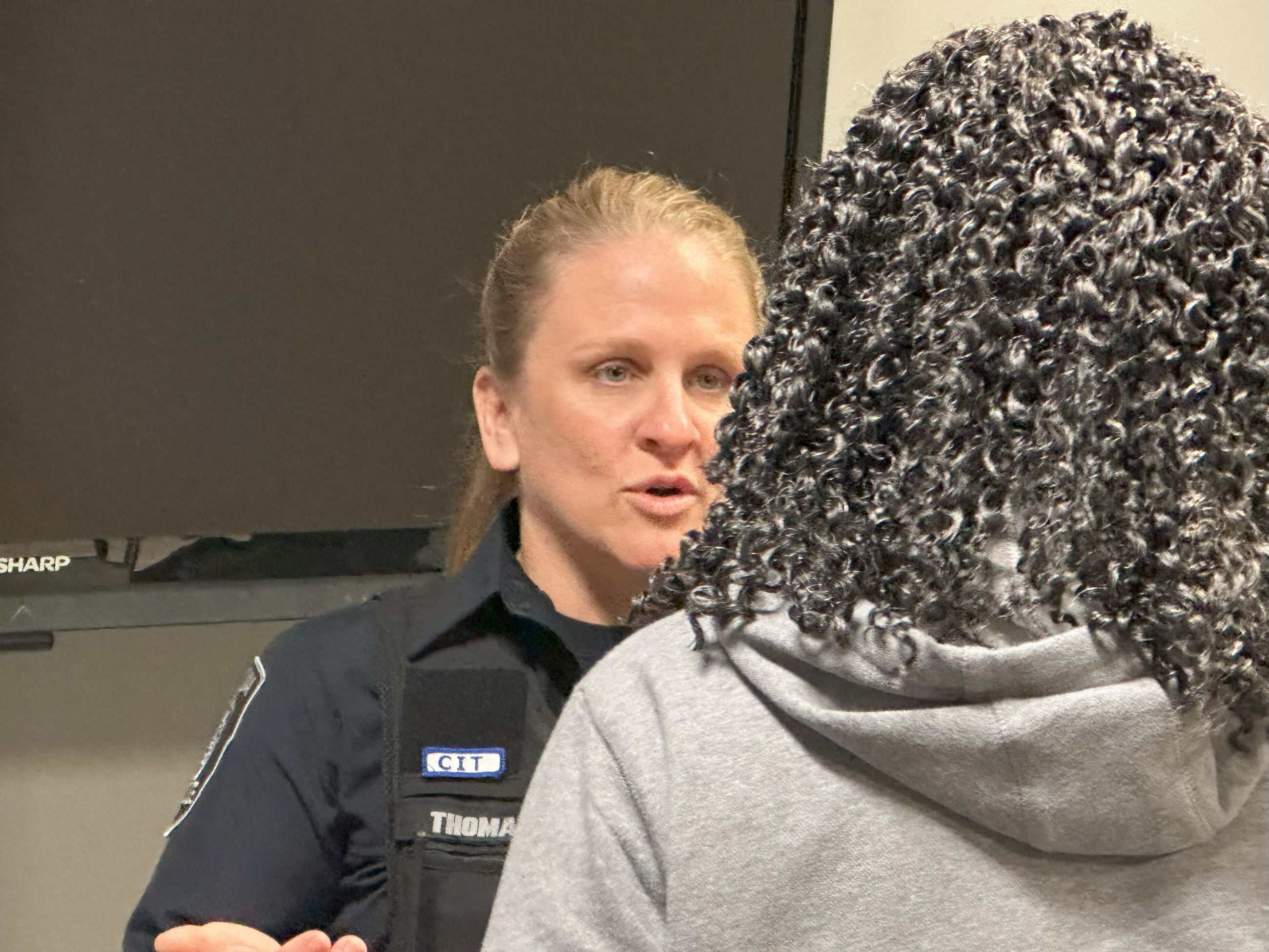 A photo of officer blair thomas talking to a woman during a self defense seminar