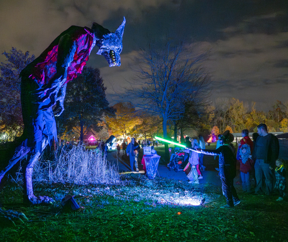 Photo of children in Halloween costumes looking at a giant werewolf figure