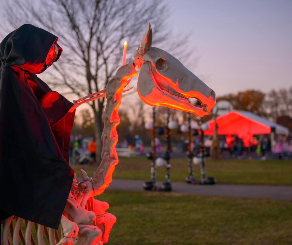 Photo of a skeleton horse with a caped figure and the Goblin fest in the background